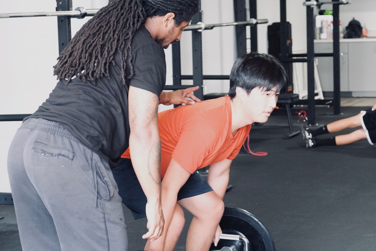 A Virtus coach setting an athlete's position at the start of a lift