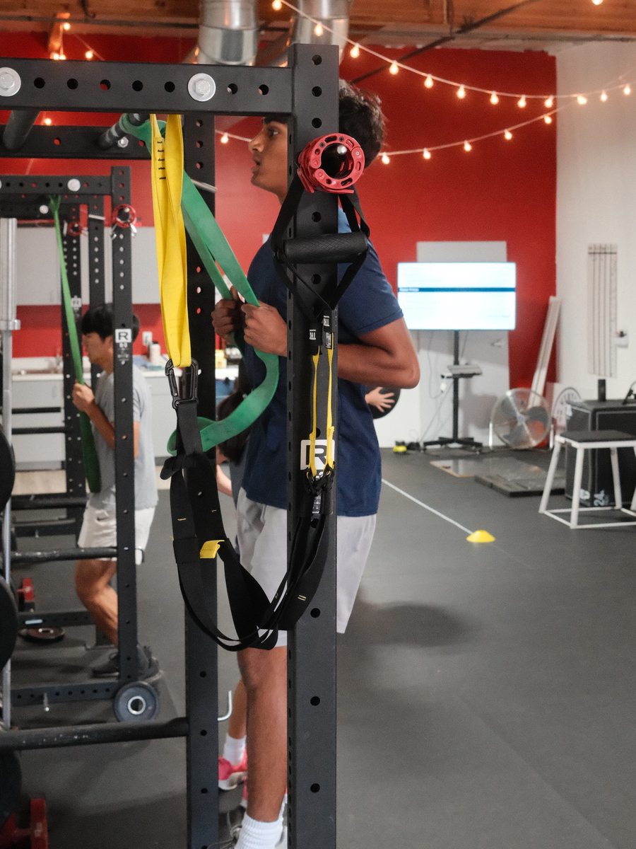 An athlete working through a resistance band exercise at the rack