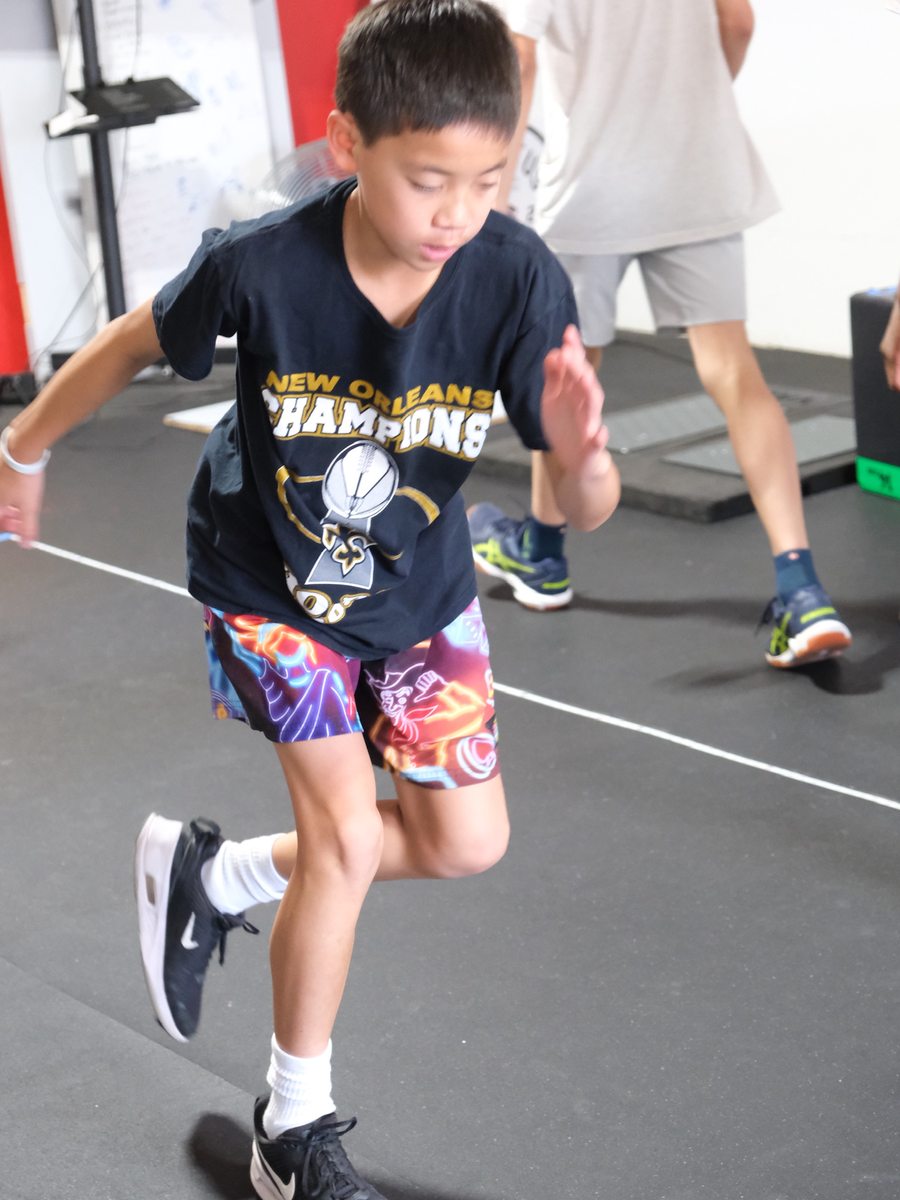 A young athlete driving a knee through a single-leg drill at Virtus